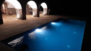 una piscina con luces en una habitación oscura en Mas Puig De Baix, en Olot
