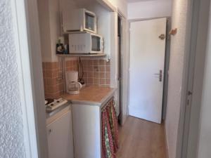 une petite cuisine avec une cuisinière et un micro-ondes dans l'établissement Clos du loup, à Uvernet