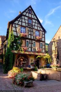 a building with a statue in front of it at Studio cosy Kaysersberg centre in Kaysersberg