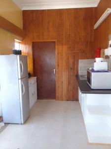 una cucina con frigorifero bianco e pareti in legno di Holope Self-Catering Accomm a Prieska