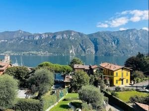 een uitzicht op een meer met een geel huis bij Casa Ketty in Bellagio