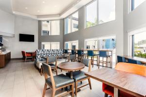 een restaurant met tafels, stoelen en ramen bij Holiday Inn Express Hotel Clearwater East - ICOT Center, an IHG Hotel in Pinellas Park