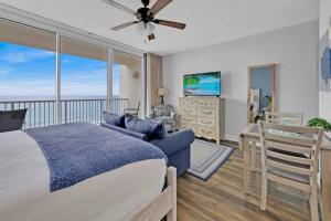 a bedroom with a bed and a balcony with a television at Beachfront Studio #909 at Majestic in Panama City Beach