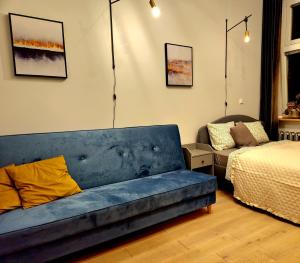 a living room with a blue couch and a bed at Spacious Apart in the Center- Main Square 300m in Wrocław