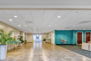 an office lobby with a hallway with palm trees at Beachfront Studio #909 at Majestic in Panama City Beach +79 photos