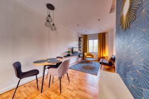 a living room with a table and chairs at LnBnB * Appartement cosy * Péronne centre * face au château in Péronne