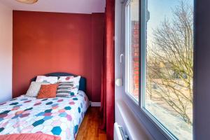 Dormitorio pequeño con cama junto a una ventana en LnBnB * Appartement cosy * Péronne centre * face au château, en Péronne