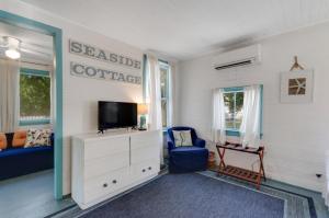een woonkamer met een tv en een blauwe stoel bij Tybee Island Sunset in Tybee Island