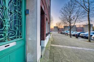 un edificio con una puerta verde en una calle en LnBnB * Appartement cosy * Péronne centre * face au château, en Péronne