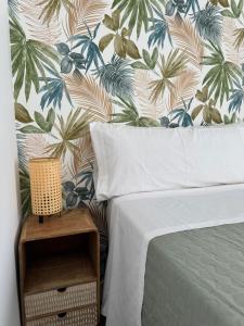 馬拉加的住宿－Plaza Victoria Apartments，一间卧室配有一张带热带壁纸的床