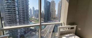 a bedroom with a large window with a view of a city at "Luxurious 2 Bed, 3 Bath Apartment in Dubai Marina - Steps Away from JBR!" in Dubai