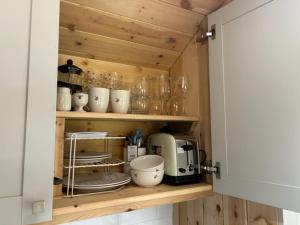 un meuble de cuisine avec une étagère pleine d'appareils électroménagers dans l'établissement Heron Leap, à Knaresborough 13 autres photos