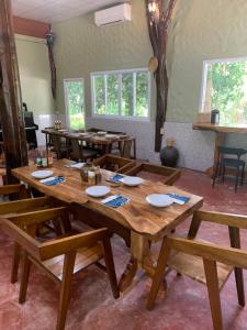 a dining room with a wooden table and benches at Krua Chehe Resort ครัวเจ๊ะเห รีสอร์ท in Ban Khok Muang