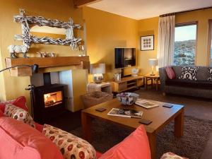 a living room with a fireplace and a couch at Shore Croft in Aultbea