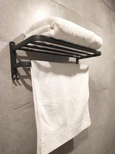 a towel rack with white towels on it in a bathroom at Jenny airport lounge in Vientiane