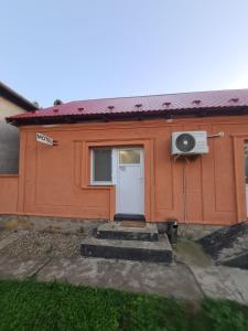 a small orange house with a door and a window at Motel in Diosig +5 photos