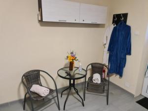 a table with two chairs and a table with a vase at Motel in Diosig