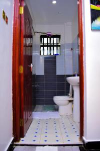 y baño con aseo y lavamanos. en Bomani Penthouse, en Kisumu