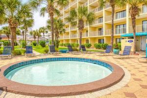 une piscine avec des chaises et des palmiers en face d'un hôtel dans l'établissement Oceanfront Condo #1320 at Summit, à Panama City Beach
