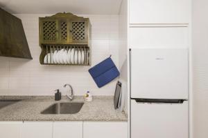a kitchen with a sink and a refrigerator at Casa Ocon in Conil de la Frontera