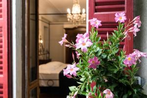 un vase avec des fleurs roses devant un miroir dans l'établissement Albergo Ristorante Madonnina, à Cantello