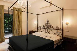 a black canopy bed in a bedroom with a window at Albergo Ristorante Madonnina in Cantello