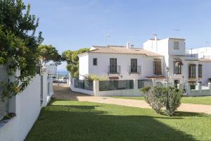 a white house with a fence and a yard at Casa Ocon in Conil de la Frontera
