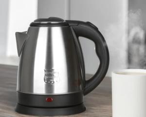 a black and silver tea kettle next to a cup at Caracciolo18 - GB in Naples
