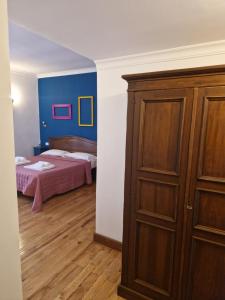 a bedroom with a bed and a wooden cabinet at Pepe's Place - Carlo Alberto in Rome