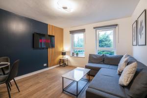 a living room with a couch and a tv at Modern 2BED Apartment-Free Parking in Edinburgh