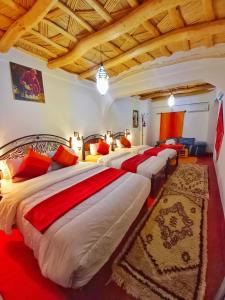 um quarto com quatro camas num quarto em Maison d'Hôte Argana em Aït Idaïr