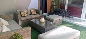 a patio with wicker chairs and tables on a porch at Home & garden suites center Granada in Granada