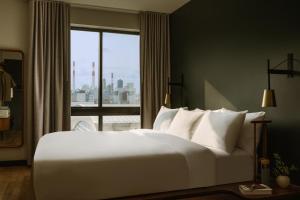 uma grande cama branca num quarto com uma janela em Sonder The Dutch em Long Island City