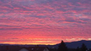 een zonsondergang met rode wolken in de lucht bij Ferienwohnung Weitblick in Offenburg