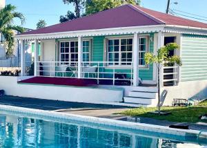 een huis met een zwembad ervoor bij Talk of the Town Inn & Suites - St Eustatius in Oranjestad