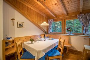 a dining room with a table and chairs and windows at Adulty Only Wasserfall Tschorn in Fundres
