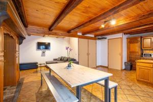 a kitchen and living room with a wooden ceiling at Maison De Vacances 6-8 Pers Proche in La Tour-dʼAuvergne