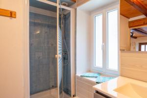 uma casa de banho com um chuveiro e uma porta de vidro em Maison De Vacances 6-8 Pers Proche em La Tour-dʼAuvergne