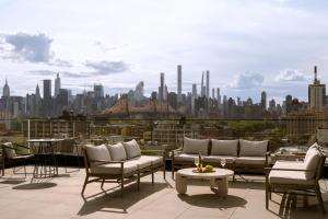 a patio with chairs and tables and a city skyline at Sonder The Dutch in Long Island City