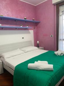 um quarto com uma cama com paredes verdes e cor-de-rosa em Casa VACANZA CHIARINA em San Benedetto del Tronto