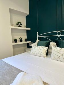 een slaapkamer met een wit bed en groene muren bij Le Case Col Sole da Silvia INTERNO 1 in Cisterna di Latina