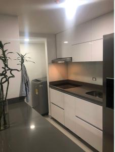 eine Küche mit weißen Schränken und einer Topfpflanze in der Unterkunft Apartamento confortable y excelente ubicación in Bello