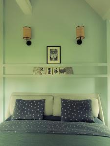 a bedroom with a bed with two pillows and two lights at La Guirtelle in Lainsecq