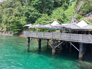 einen Pier mit Tischen und Sonnenschirmen auf dem Wasser in der Unterkunft OITO ZERO UM - Flat Sol Victoria Marina in Salvador