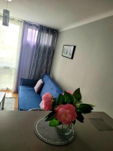 a living room with a table with a vase of flowers at Apartament Centrum Jana Pawła II in Warsaw