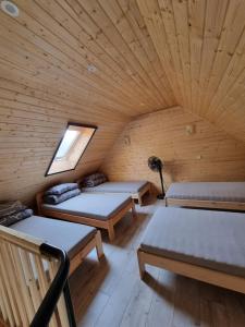 een kamer met 3 bedden in een houten hut bij Sodyba "Kristina" in Biržai