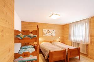 twee bedden in een kamer met houten wanden bij Casa Silvia in Livigno