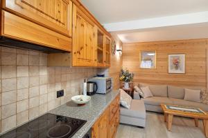 eine Küche und ein Wohnzimmer mit einem Sofa in der Unterkunft Casa Silvia in Livigno