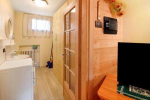 ein Badezimmer mit einer Holztür und einem TV in der Unterkunft Casa Silvia in Livigno + 20 Fotos