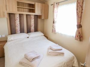 a small bedroom with a bed with towels on it at E10 Eagle Meadows in Paignton